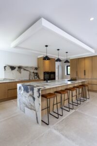 Ligna oak kitchen island with waterfall stone worktop and a row of leather bar stools