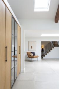 Ligna full-height oak cabinetry beside a glazed display cabinet and bright hallway