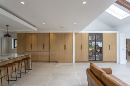 Ligna full-height oak storage wall with a concealed doorway and glazed display cabinet