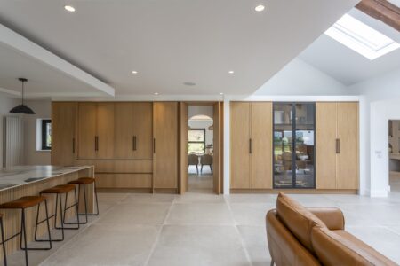 Ligna oak storage wall with the concealed doorway open beside the display cabinet