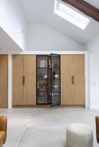 Full-height black-framed display cabinet set between Ligna oak cupboards