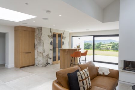 Ligna oak drinks cabinet with orange bar stools and views through the glazed doors