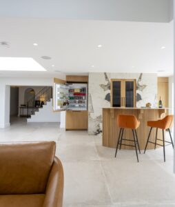 Open Ligna drinks cabinet with stone surround and orange bar stools