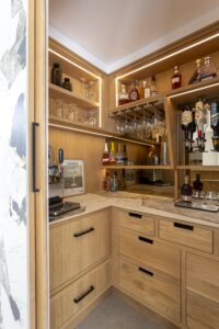 Interior of the Ligna walk-in pantry with oak drawers and illuminated shelves