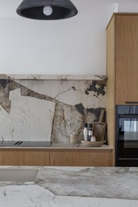 Ligna oak base cabinets beneath a veined stone splashback and black pendant light